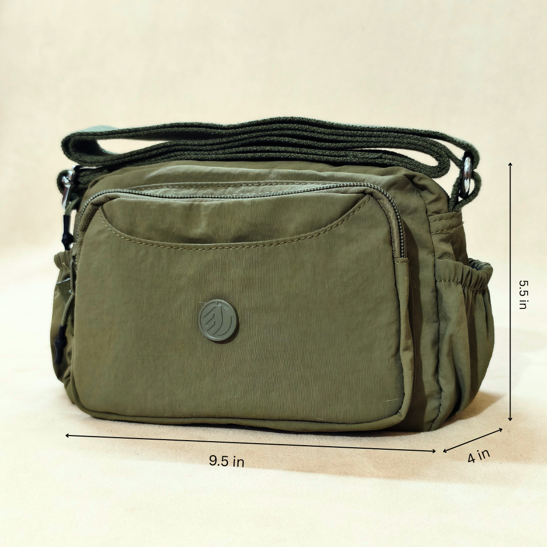 Military Green Sling Bag With Measurements In Front Of Beige Background.