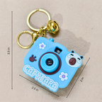 Blue capybara-shaped camera keychain with measurements on a beige background