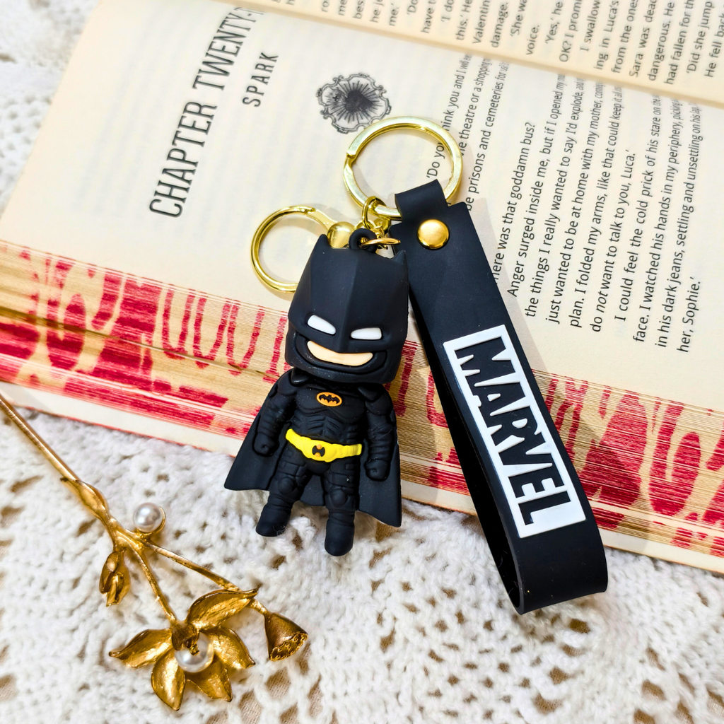Black and yellow superhero keychain with Marvel logo on a textured surface