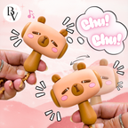 Two cartoonish dog-shaped rattles held by hands with a pink background and 'Chu! Chu!' text.