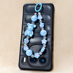 Phone case with a blue beaded chain on a beige background