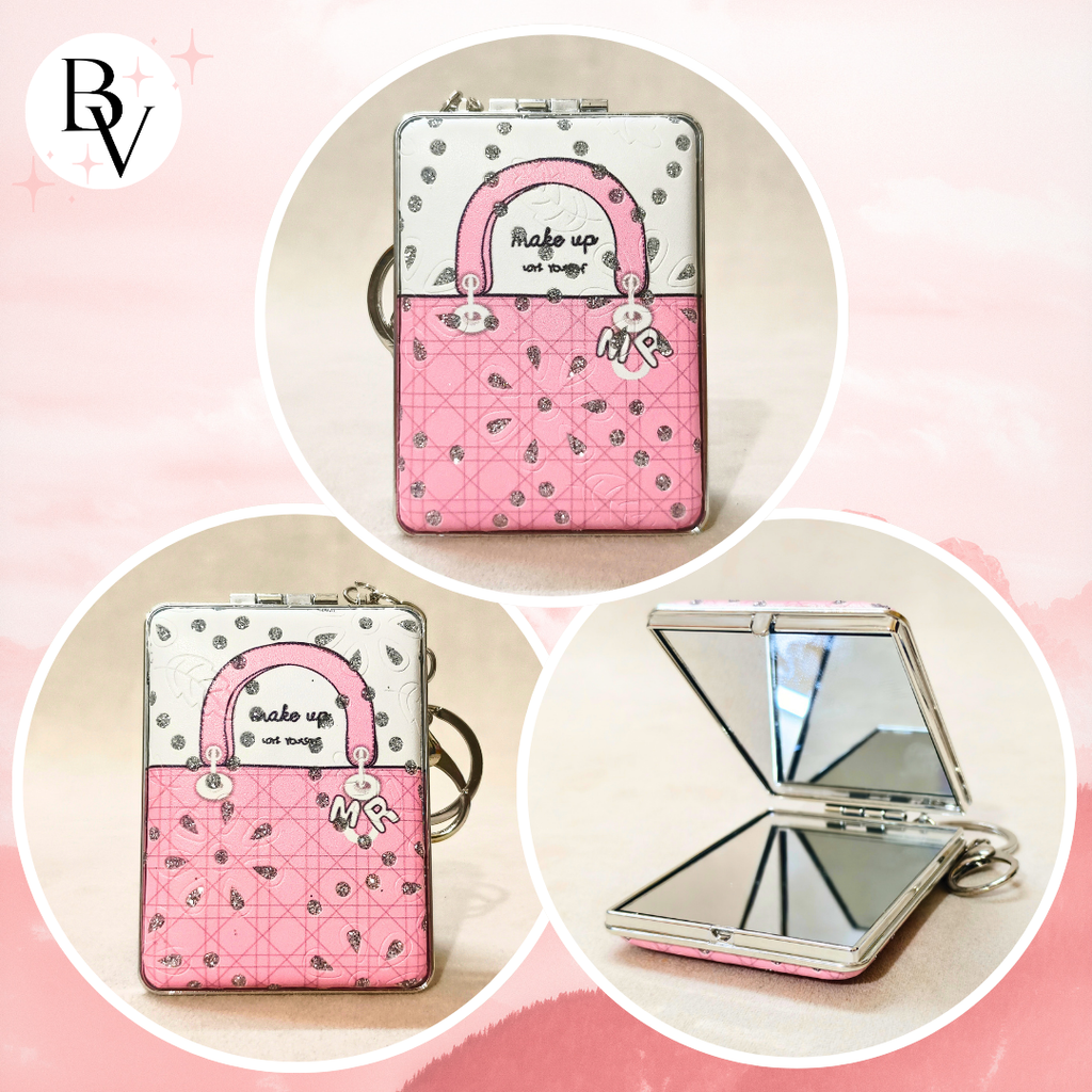 A pink and white handbag-shaped compact mirror with a silver frame, shown closed in two views and open to reveal a mirror inside. The compact features a quilted pattern, a pink top handle, and a silver keyring attachment.