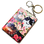 A rectangular metal keychain case featuring a colorful floral and cat print design, embellished with rhinestones, and attached to a silver split keyring on a white background.