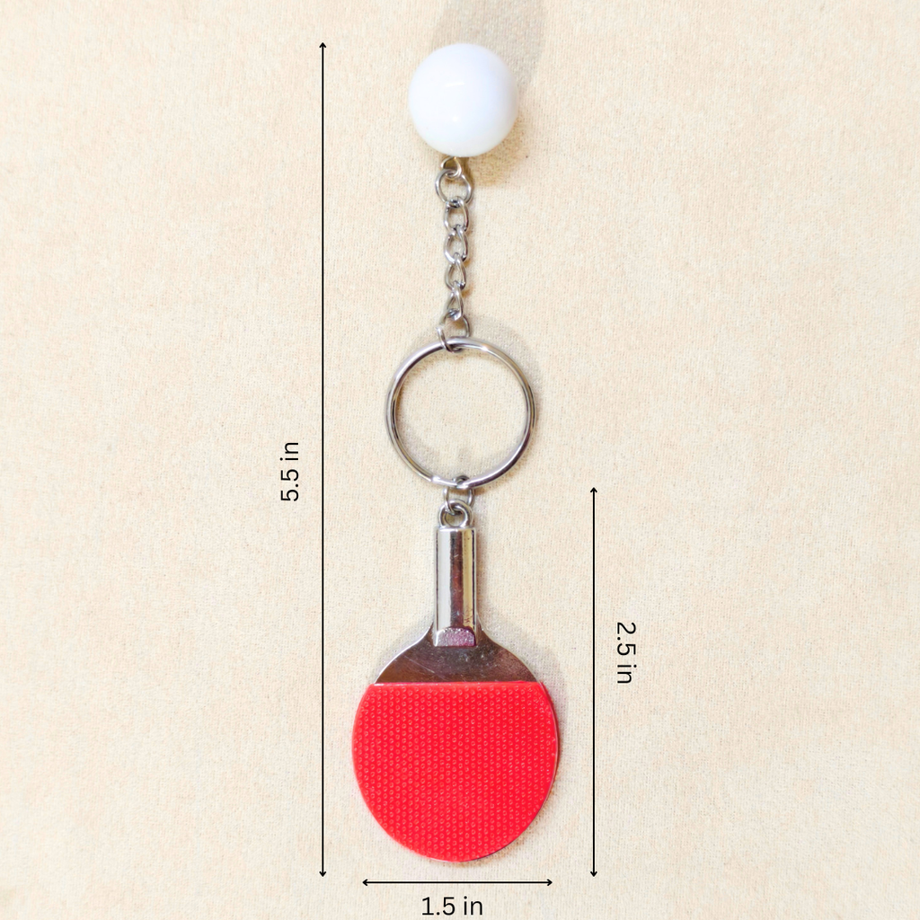 A ping-pong themed keychain featuring a red paddle and white ball, with black dimension lines and text showing measurements of 5.5 inches, 2.