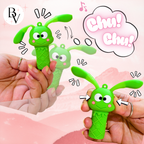 Green rabbit-shaped ice cream toy with cartoon features held by hands on a pink background.