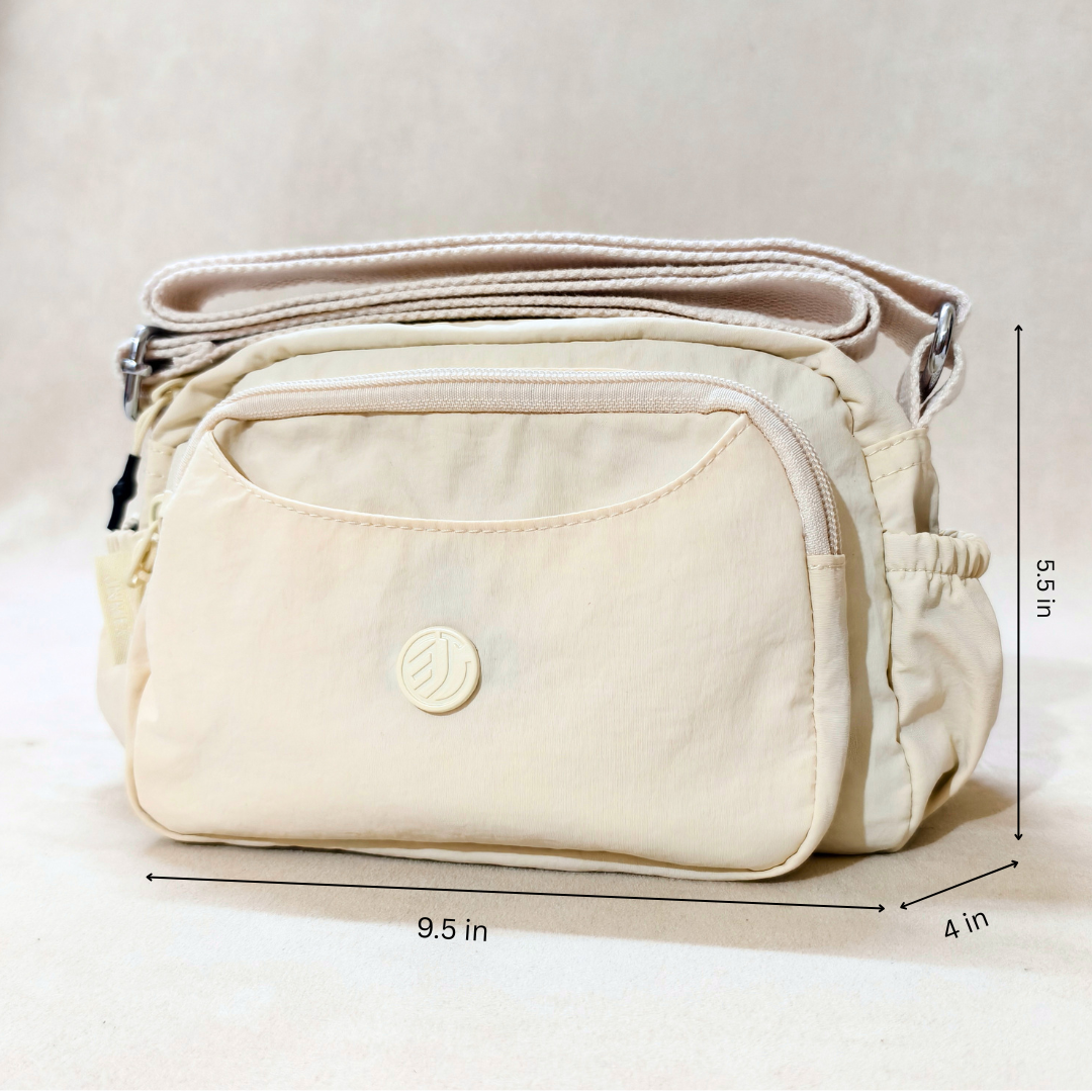 Cream Ivory Sling Bag With Measurements In Front Of Beige Background.