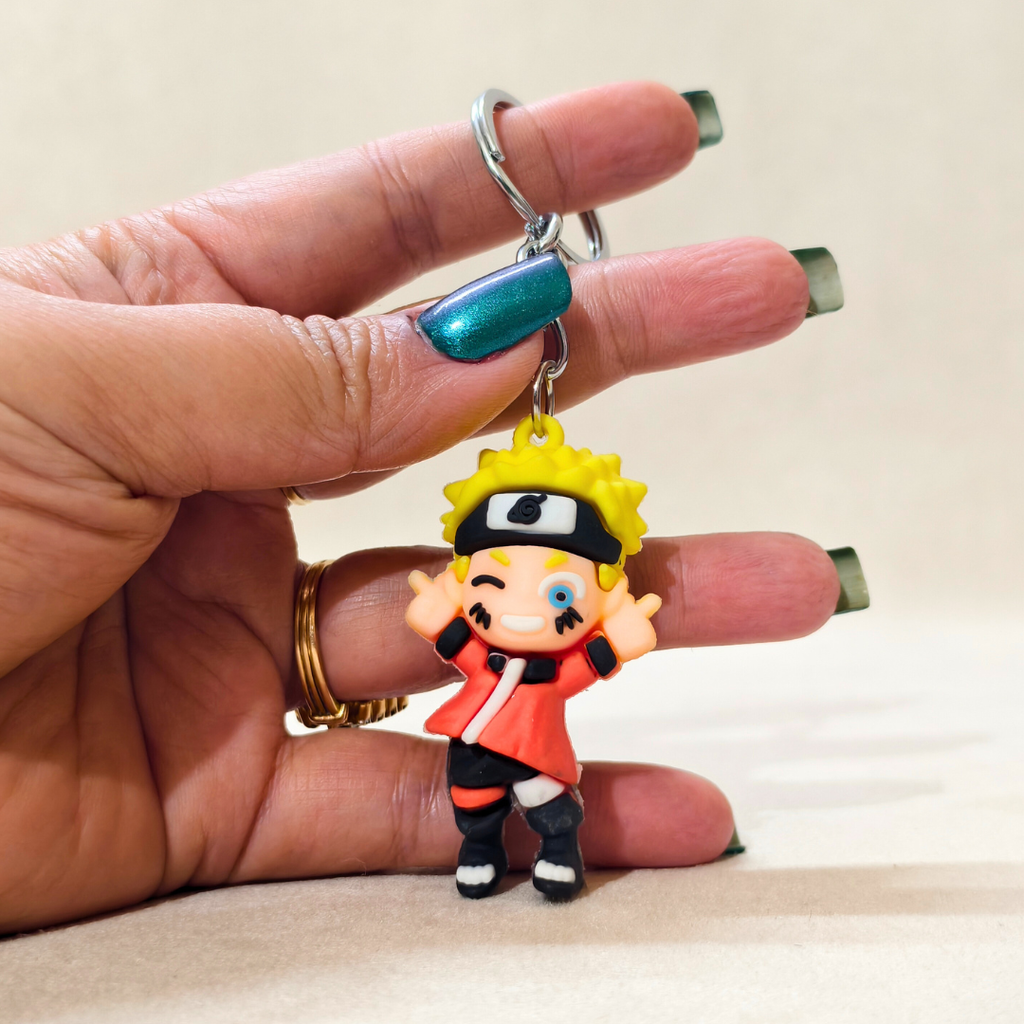Hand holding a keychain with a character figure against a neutral background