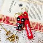Deadpool keychain with red strap on a textured surface