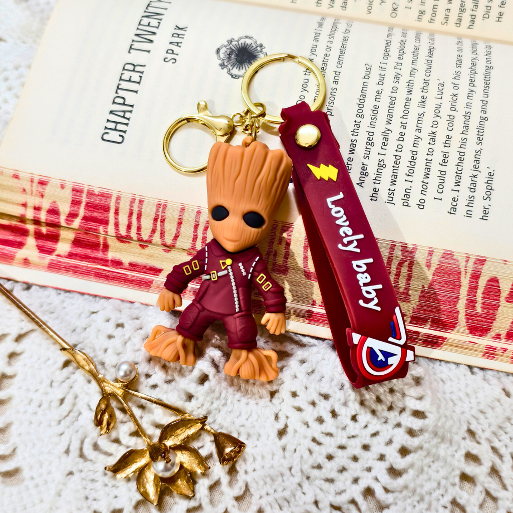 Groot keychain with a 'Lovely baby' strap on a textured surface