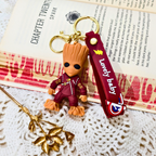 Groot keychain with a 'Lovely baby' strap on a textured surface