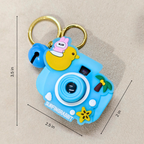 Blue camera-shaped keychain with a duck design and measurements on a beige background