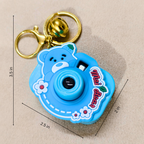 A blue cartoon bear camera keychain with a gold clasp and bell, shown with dimension lines indicating measurements of 3.5 in, 2.