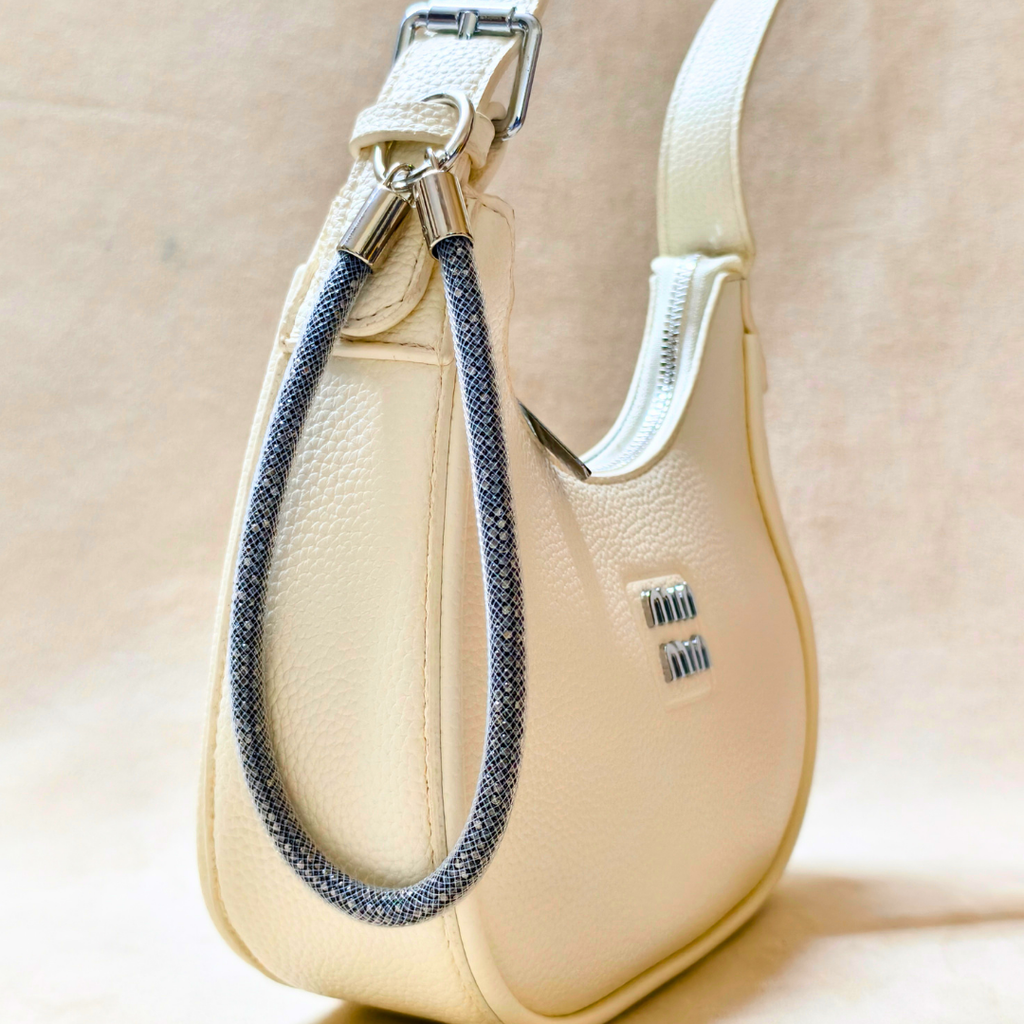 Beige handbag with a braided strap on a beige background