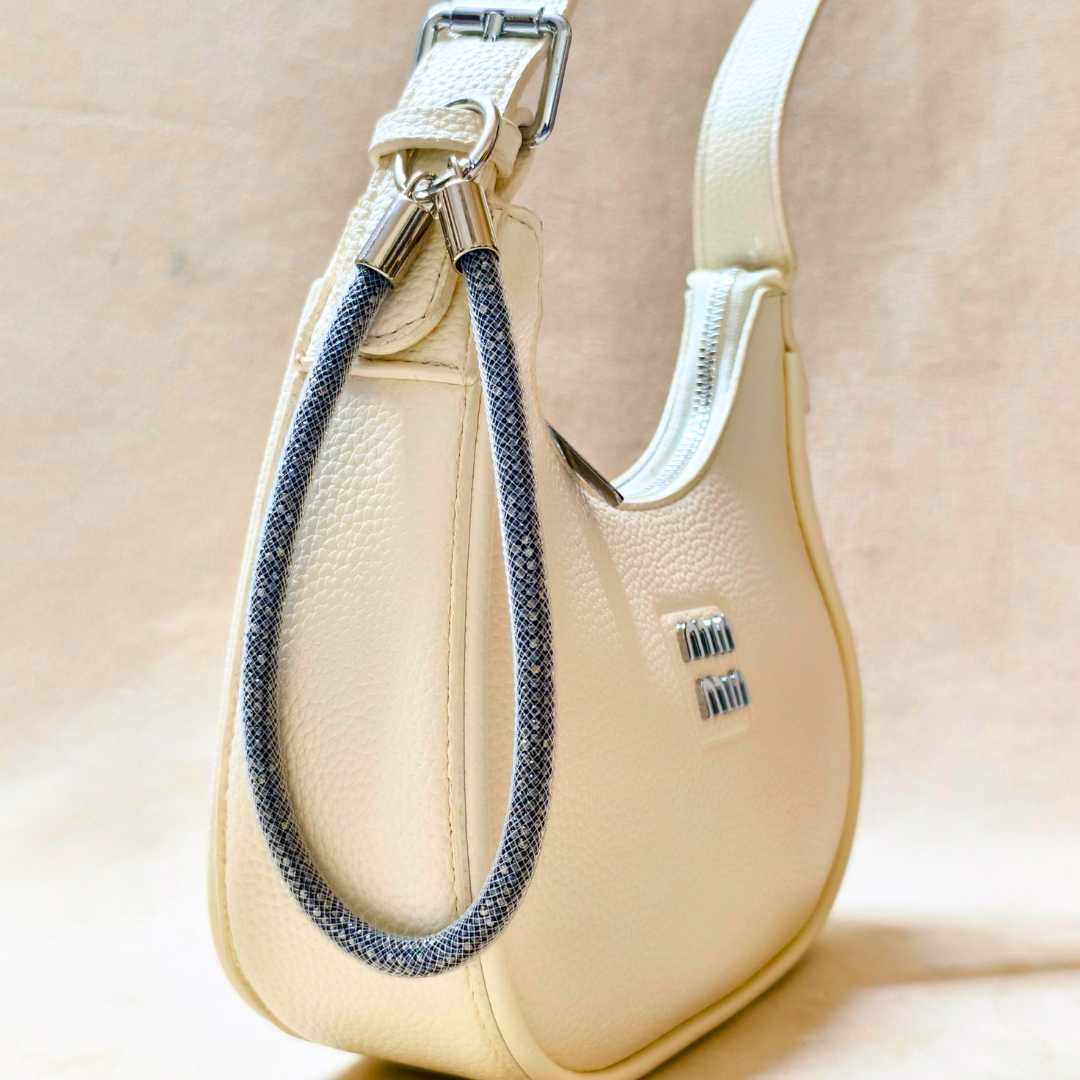 Beige handbag with a braided strap on a beige background