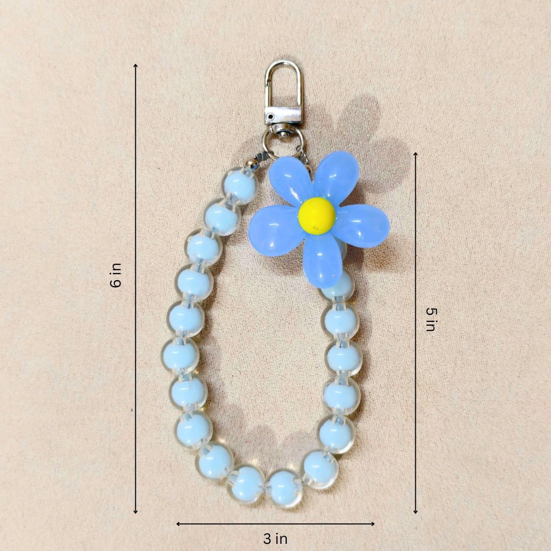 Blue Flower Phone Charm With Measurements In Front Of Beige Background.