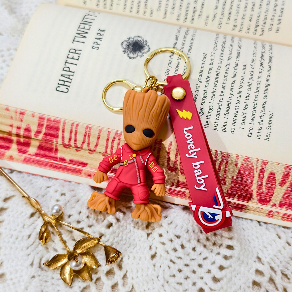 Keychain with character figure and 'Lovely baby' strap on an open book