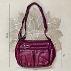 Magenta handbag with measurements on a textured beige background