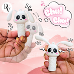 White rabbit-shaped toy with cartoon face held by hands on a pink background
