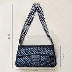 Black quilted handbag with a patterned strap on a light beige background, showing measurements.