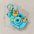 Capybara-themed toy camera with keychain on a beige background
