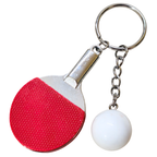 A novelty table tennis keychain featuring a miniature paddle with a red textured grip and a white plastic ball hanging from a silver metal chain and key ring, shown on a plain white background.
