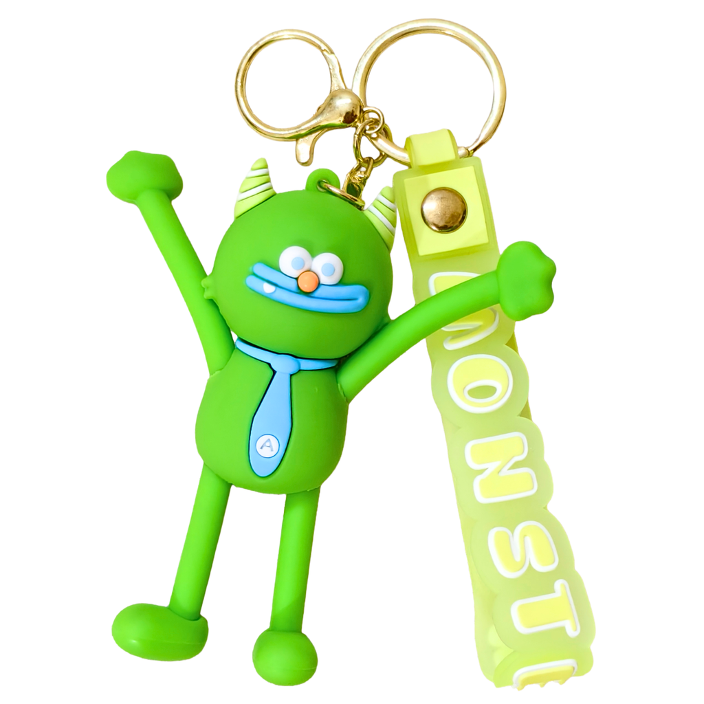 A green cartoon monster keychain with raised arms, wearing a light blue tie, attached to a matching green and yellow strap that reads MONSTI, on a plain white background.
