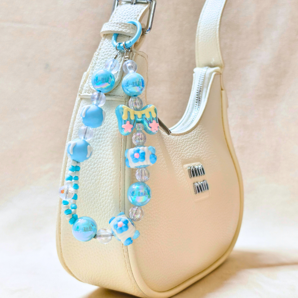 Beaded blue strap with decorative elements on a beige handbag