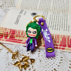 Joker keychain with purple strap on a textured surface