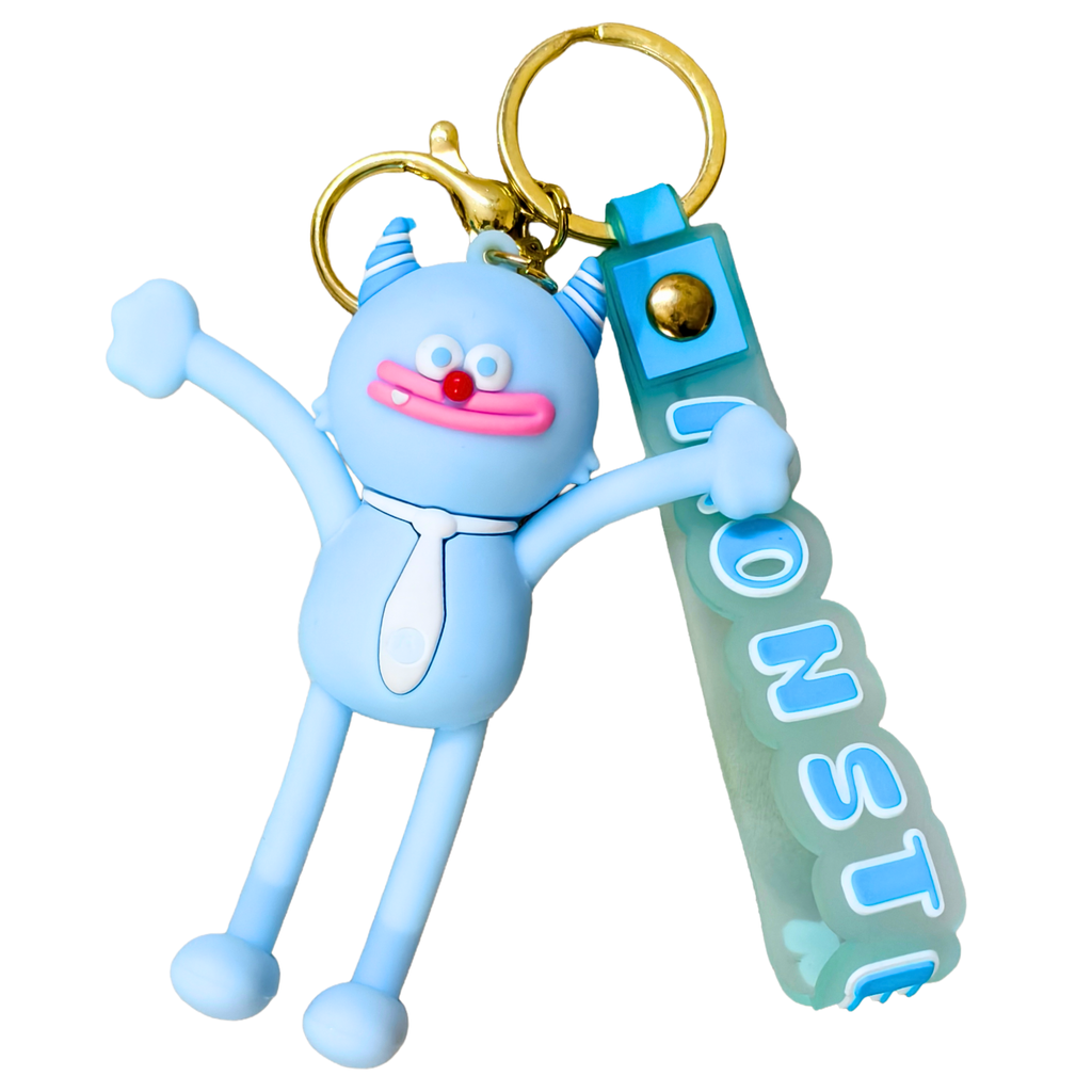 A light blue rubber monster keychain with a gold clasp and a translucent blue-green tag that reads 'MONSTER'.