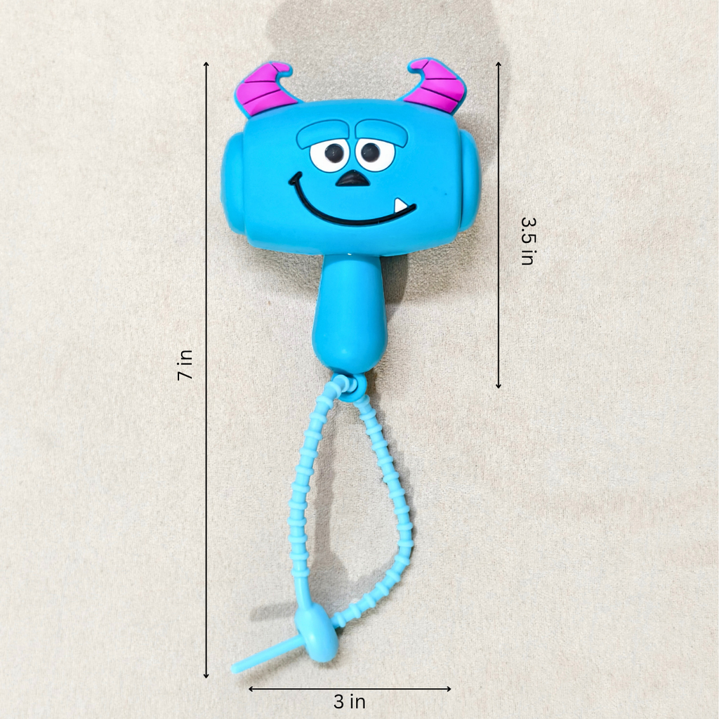 A blue monster-shaped hand sanitizer holder with pink horns and a coiled wrist strap, shown on a light beige textured background with printed dimension labels indicating 7 in height, 3.5 in width, and 3 in depth.