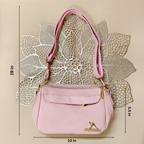 Pink handbag with gold accents on a textured beige background