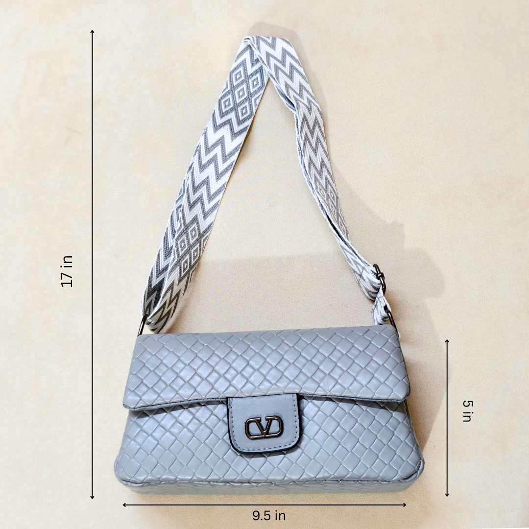 Gray quilted handbag with a patterned strap on a beige background, showing measurements.