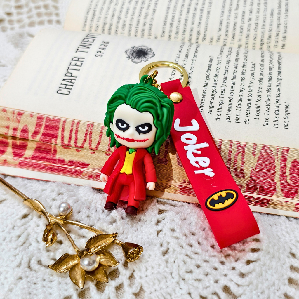 Joker keychain with red strap on a book