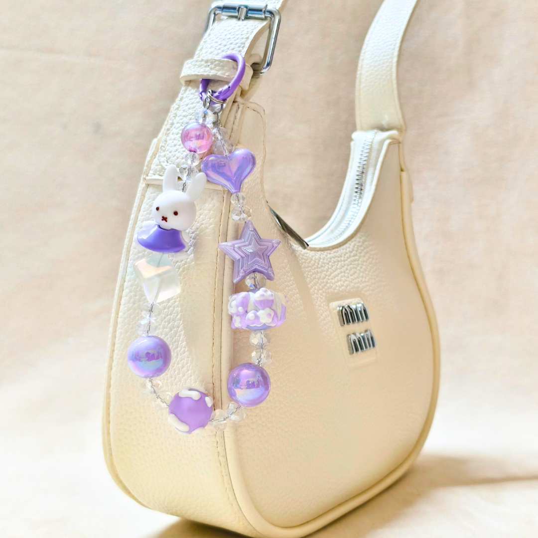 Decorative strap with charms on a beige handbag
