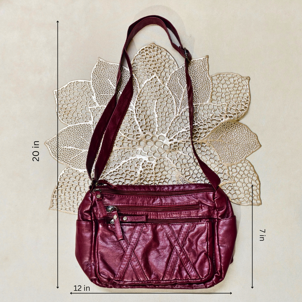 Maroon handbag with measurements on a beige background