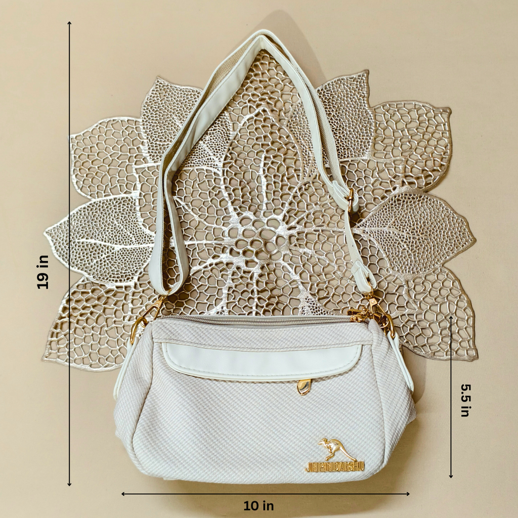 White handbag with gold accents on a beige background with leaf patterns