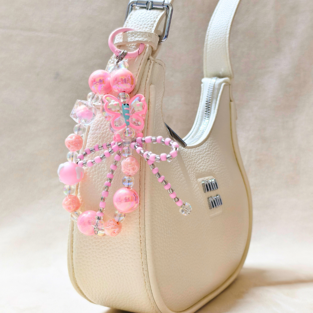 Beaded butterfly charm on a beige handbag