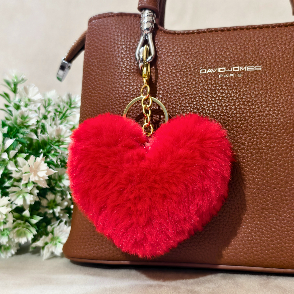 Red Heart plushie on a brown bag in front of a beige background