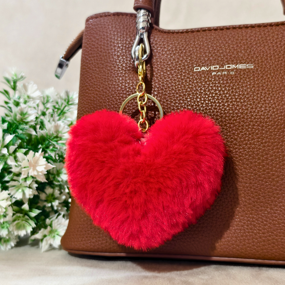 Red Heart plushie on a brown bag in front of a beige background