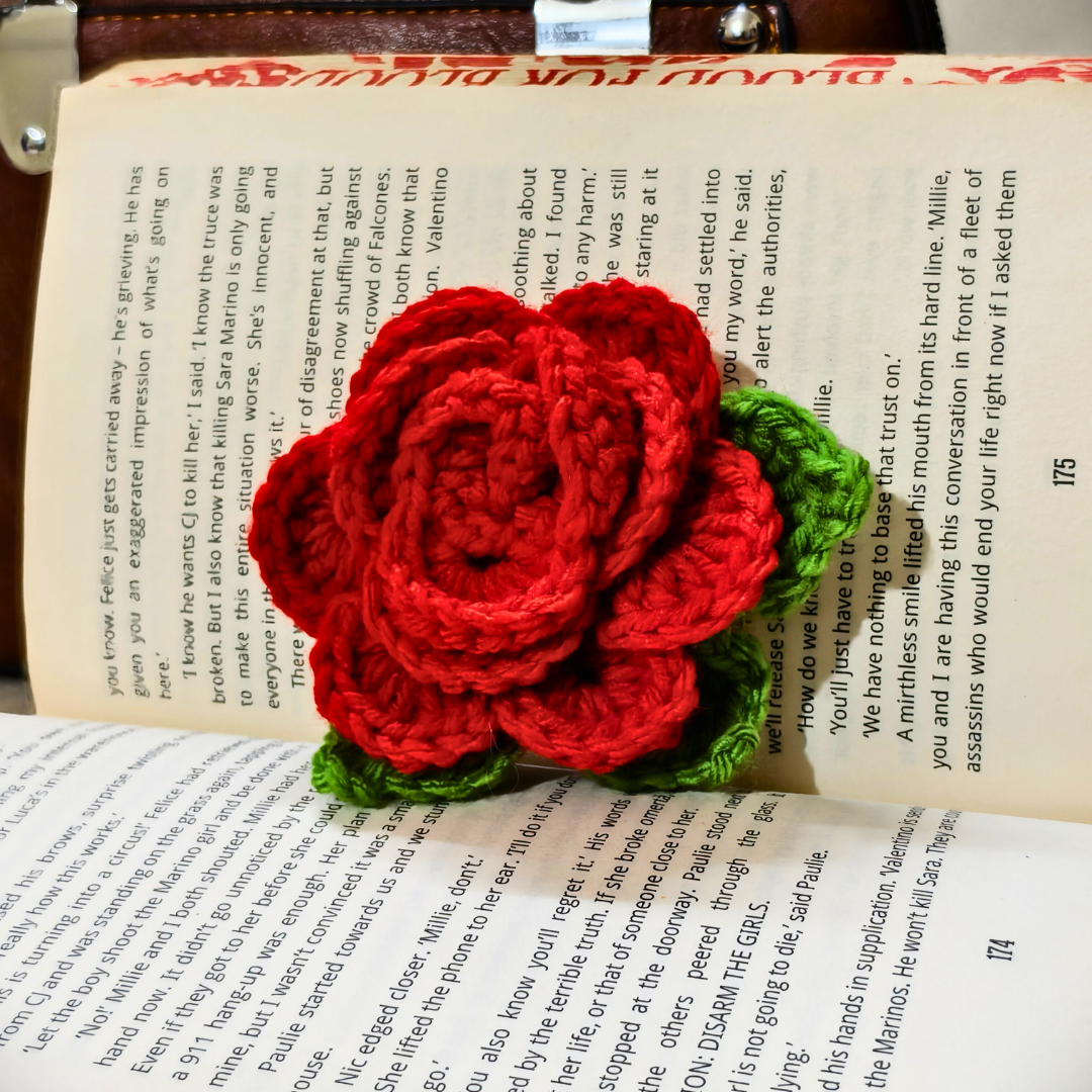 Crocheted red rose on an open book