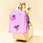Pink and gold keychain with cartoon character on a beige background