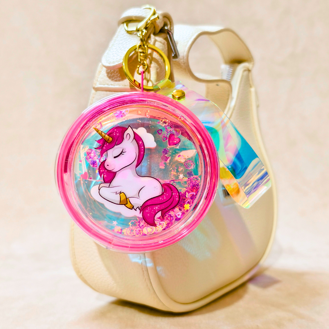 Gold phone case with a pink unicorn charm on a beige background