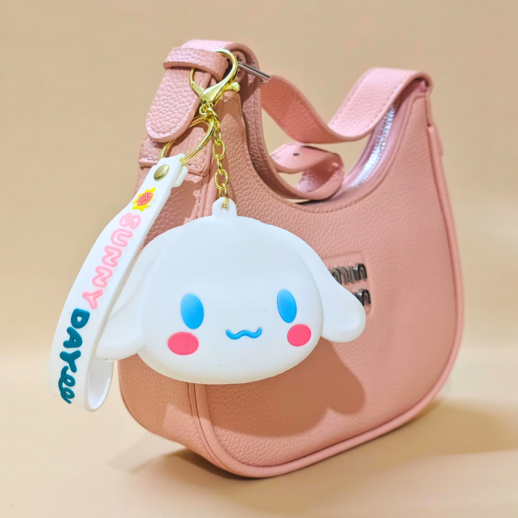 Pink handbag with a cute character keychain on a beige background