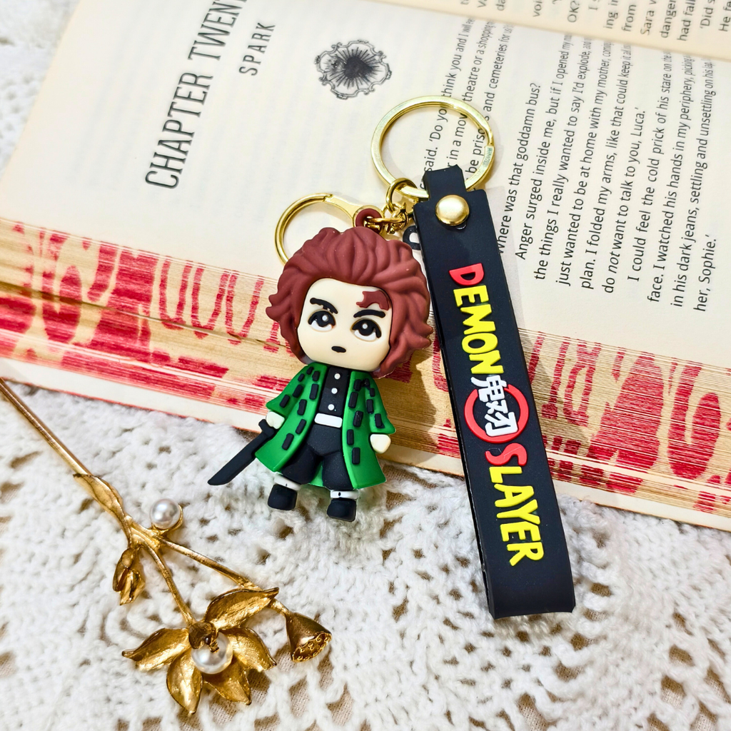 Keychain with character figure and 'Demon Slayer' tag on a textured surface