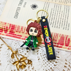 Keychain with character figure and 'Demon Slayer' tag on a textured surface