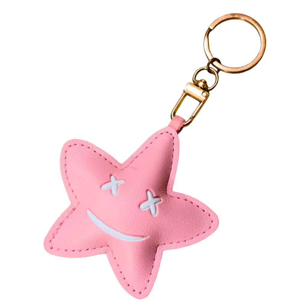 Pink star-shaped keychain with a smiley face on a white background
