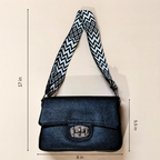 Blue denim handbag with a patterned strap on a beige background, showing measurements.