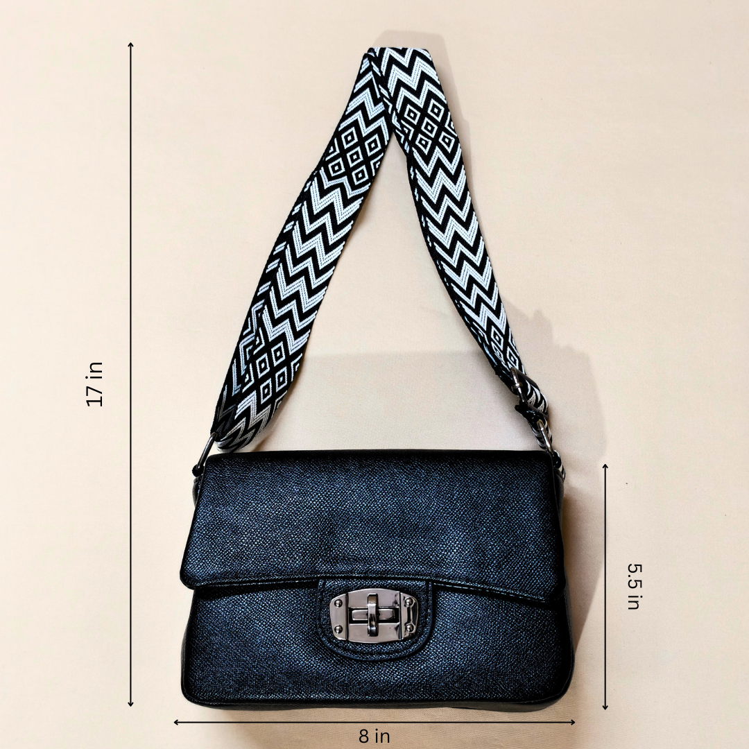 Blue denim handbag with a patterned strap on a beige background, showing measurements.