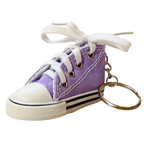 A miniature purple canvas high-top sneaker keychain with white laces tied in a bow, a white rubber toe cap, and a gold-tone key ring on a plain white background.