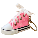 A miniature pink canvas high-top sneaker keychain with white laces tied in a bow, a white rubber toe cap, black and white stripes on the sole, and a gold metal key ring.
